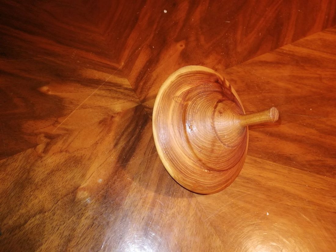 Gedrechseltes Holzstück auf einer Holzoberfläche